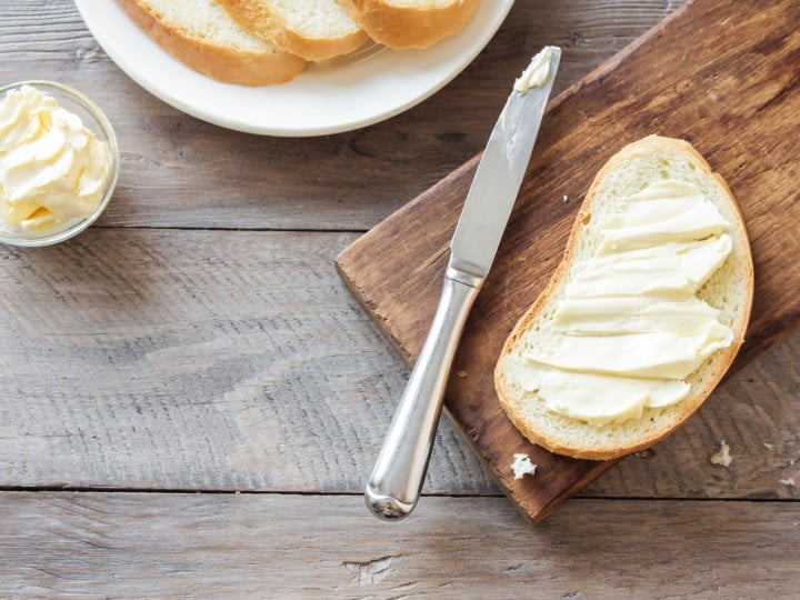 Butter and bread for breakfast on rustic wooden background with copy space. Morning breakfast, butter and toasts.