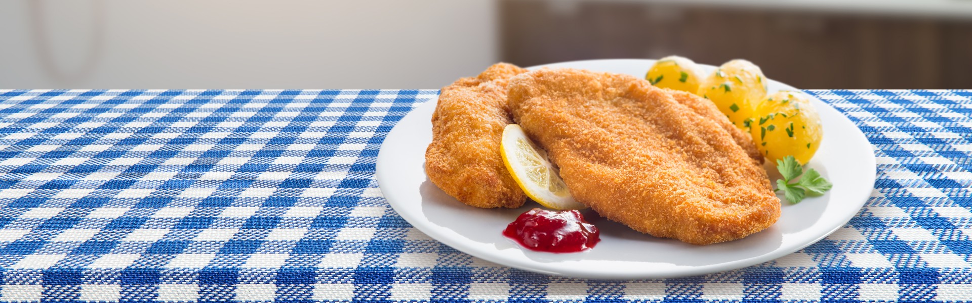 SPAR Feine Küche Header SPAR Feine Küche Header Schnitzel mit Petersilkartoffeln auf kariertem Tischtuch
