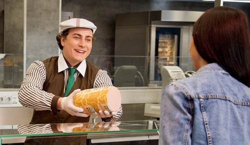 Feinkostabteilung mit zwei Mitarbeiter und einer Kundin