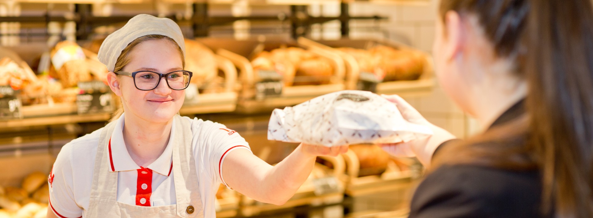 Lehrling Bäckerei bedient Dame