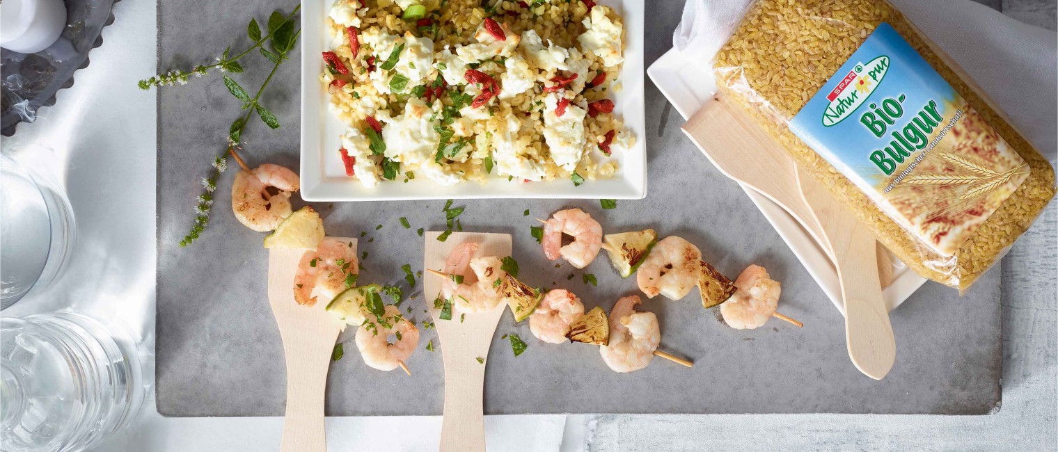 Raclette mit Bulgur und Garnelen-Limetten-Spießen