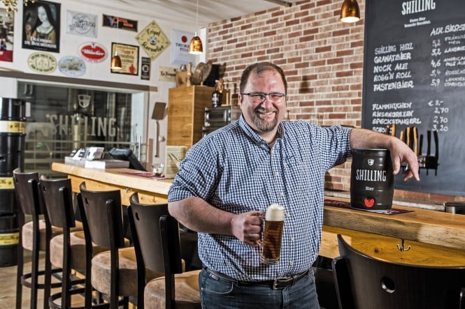 Shilling Bier Uli Bacher mit einem Glas Shilling Bier