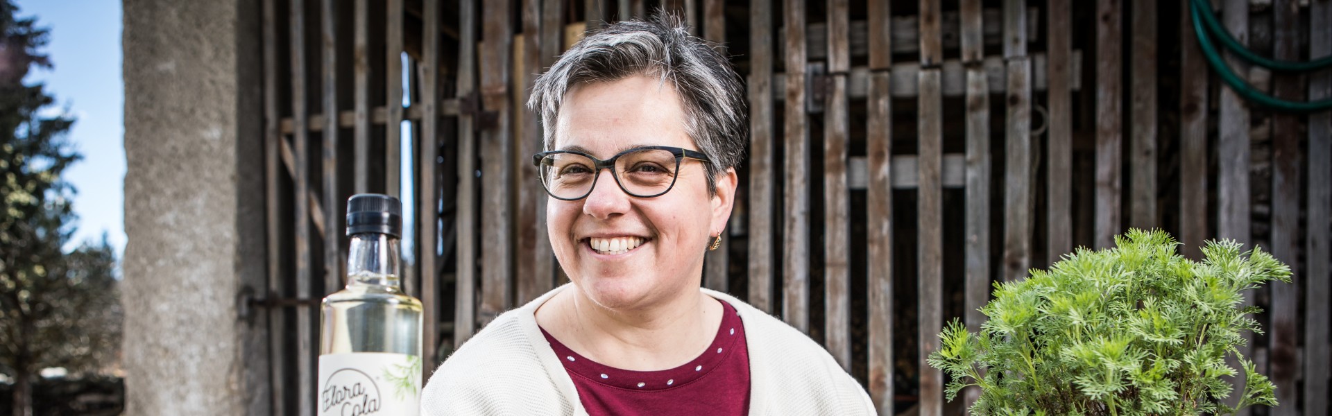 Alexandra Riepl mit ihrem Produkt Flora Cola und der Eberraute (Pflanze)