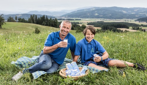 Jauntalmilch Franz Skuk und Sohn sitzen mit Milchprodukten in der Wiese