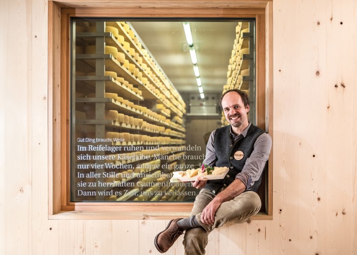 Kaslabn Michael Kerschbaumer von Kaslabn sitzt mit selbst gemachtem Käse vor dem Reifelager