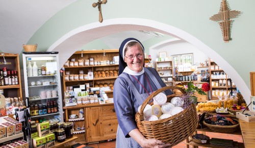 Kloster Wernberg Eine Klosterschwester im Klostergeschäft mit einem Korb voller Milchprodukte