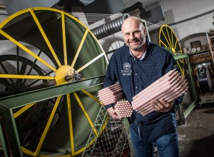 Michael Gasser mit seinen Kerzen in der Hand in seiner Produktionsstätte