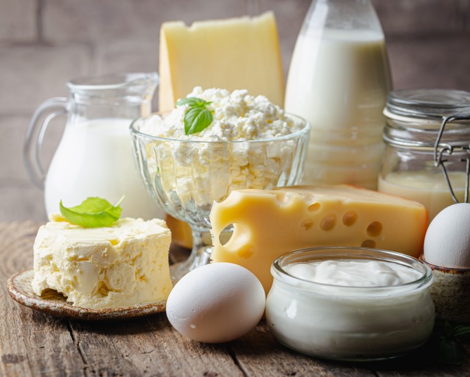 Fresh dairy products, milk, cottage cheese, eggs, yogurt, sour cream and butter on wooden table