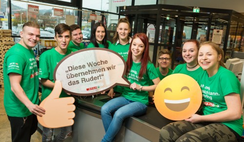 Gruppe von SPAR Lehrlinge halten Schild mit Spruch "Diese Woche übernehmen wir das Ruder!"