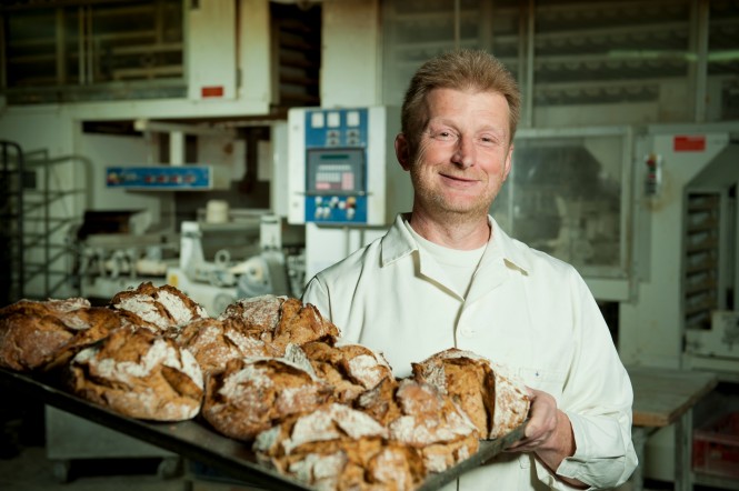 SPAR-Lieferant-Bäckerei-Biebl Bäcker Biebl mit einem Blech voller Brotlaibe