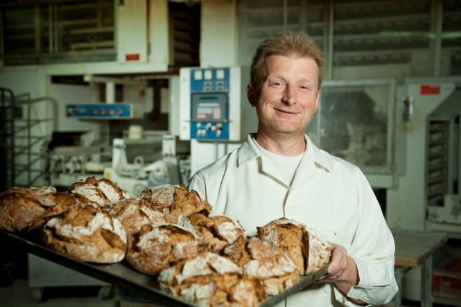 SPAR-Lieferant-Bäckerei-Biebl Bäcker Biebl mit einem Blech voller Brotlaibe