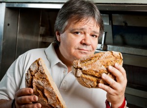 Bäcker Kurt Kranich hält einen halbierten Laib Brot