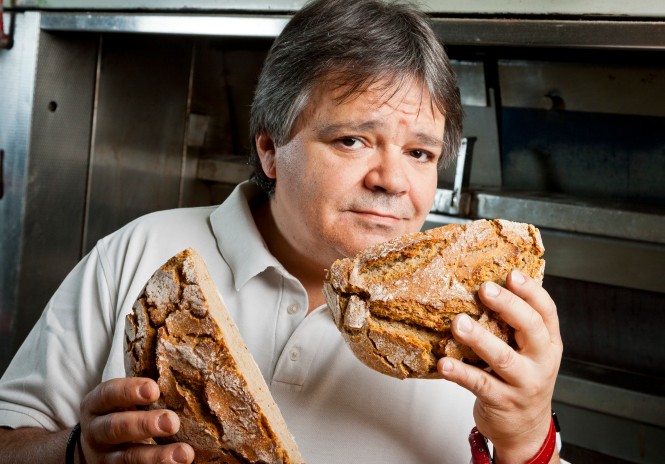 Bäcker Kurt Kranich hält einen halbierten Laib Brot