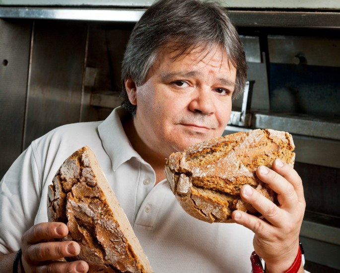 Bäcker Kurt Kranich hält einen halbierten Laib Brot