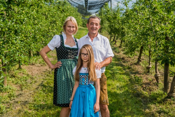 Herbert und Hannelore Hasenhüttel mit Tochter zwischen Apfelbäumen 