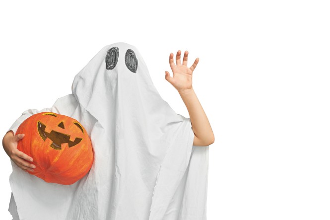 Happy Halloween! Cute little kid in ghost costume on teal background.