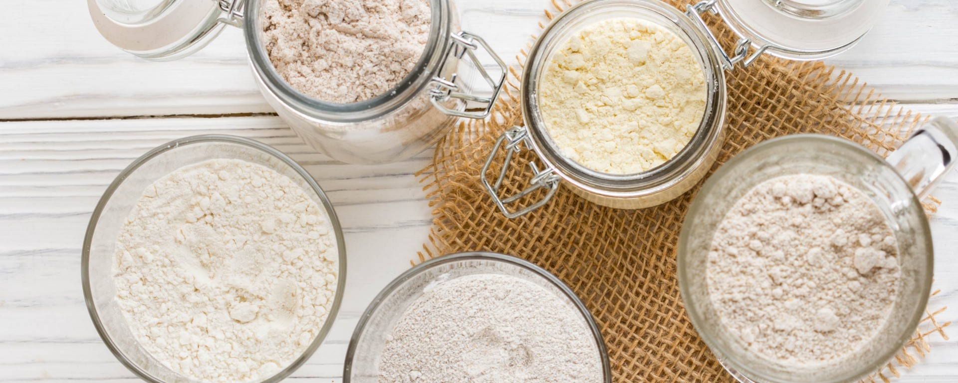 Different flour in glass jars, wheat, corn, rye, oats, spelt, flax