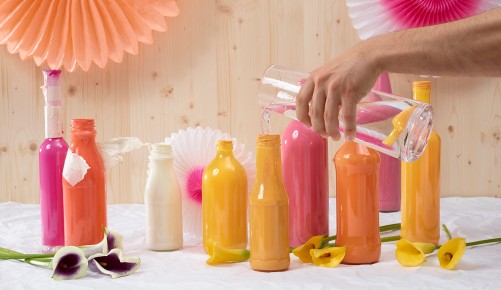 Bunte Flaschen mit Wasser befüllen