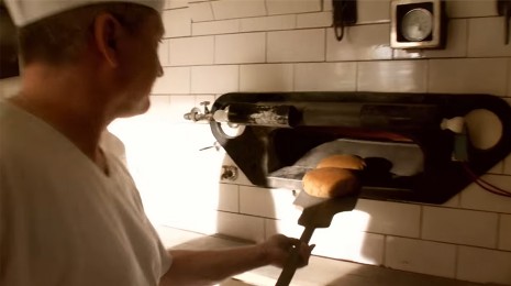 Frisch gebackenes Brot wird aus dem Ofen geholt