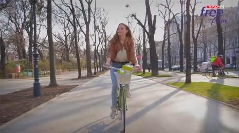 Frau fährt Fahrrad durch Allee