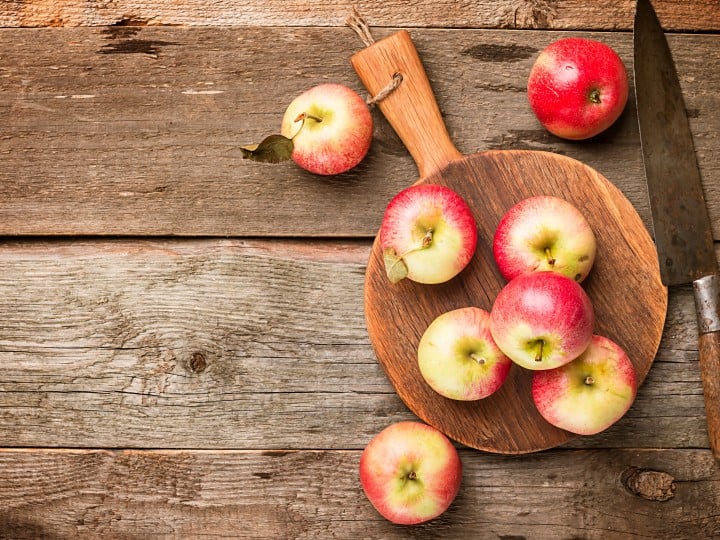 Fresh organic ripe apples on rustic wooden table, top view with copy space