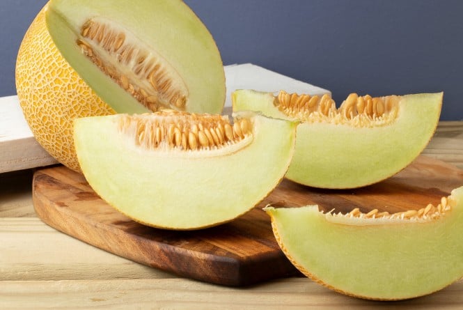Aufgeschnittene Galia melone auf einem Holzbrett