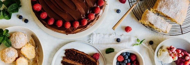 Ein Tisch mit beliebten Süßen Rezepten: Schoko-Torte mit Himbeeren, Apfelschlangerl, Topfenknödel und Eis