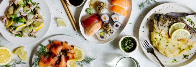 Ein Tisch mit beliebten Fisch-Rezepten: Sushi, Räucherlachs, gegrillte Calamari, Saibling mit Püree