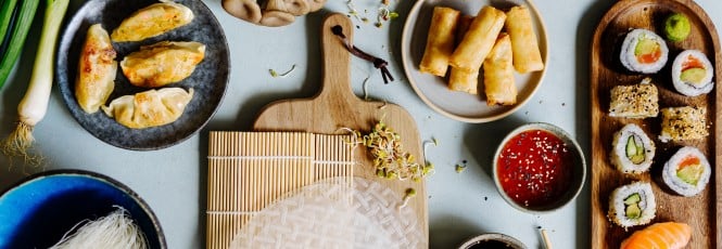 Bild mit asiatischen Gerichten wie Sushi, Frühlingsrollen, und Gyoza