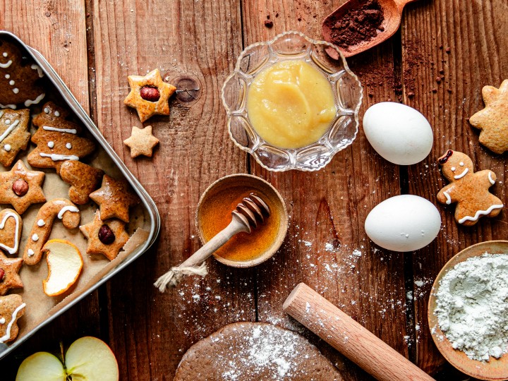Zutaten für Lebkuchen auf einem Tisch wie Apfelmus, Honig, Gewürze