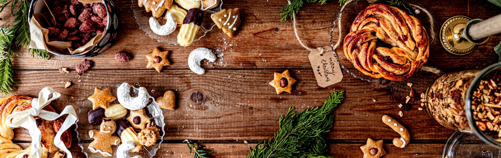 Ein Holztisch mit weihnachtlichem Gebäck, Keksen, gebrannten Mandeln 