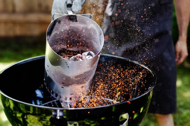 Griller wird mit Kohle angeheizt