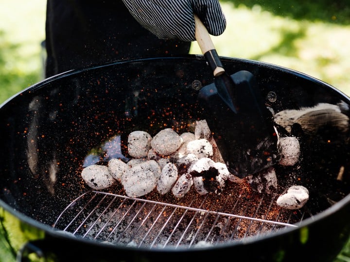 Griller wird mit Kohle angeheizt