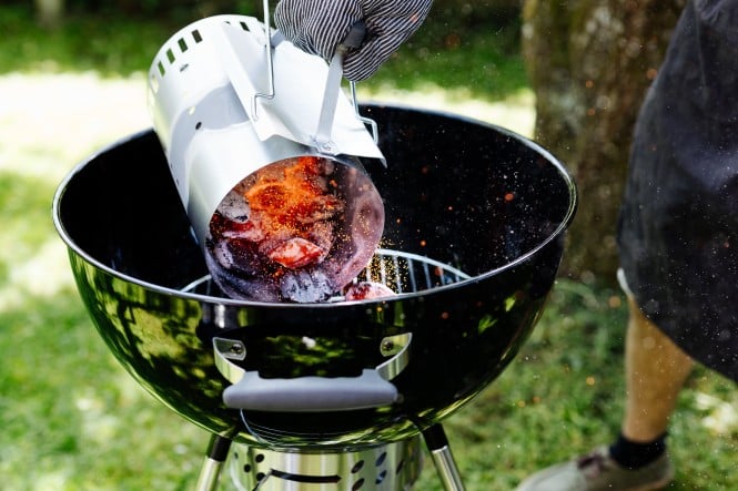 Griller wird mit Kohle angeheizt