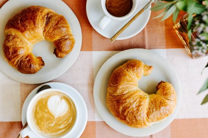 Gedeckter Tisch mit Croissant und Capuccino
