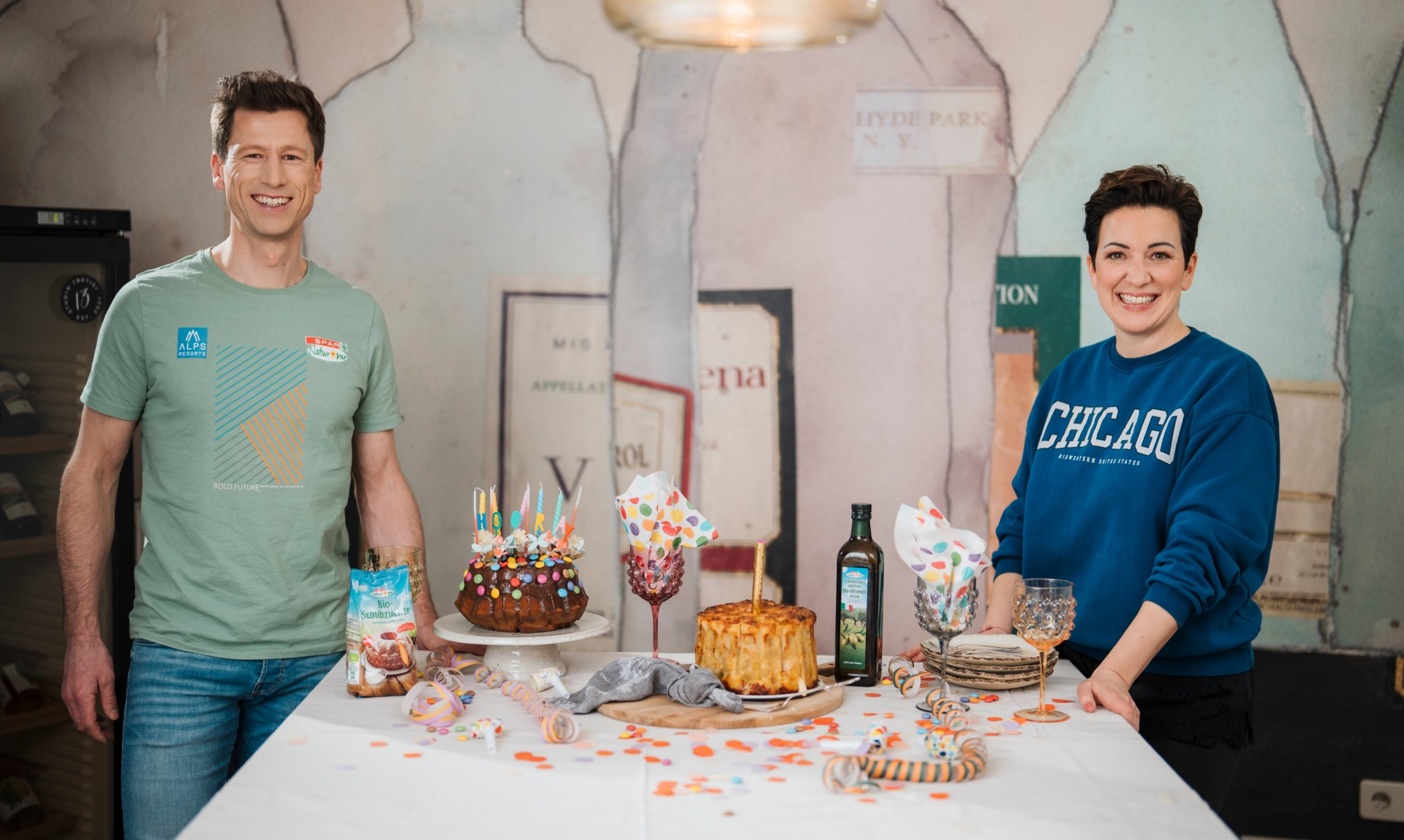 SPAR Mahlzeit! Kindergeburtstag Tici und Hannes stehen an einem Tisch auf dem die Nudeltorte und ein Kuchen stehen
