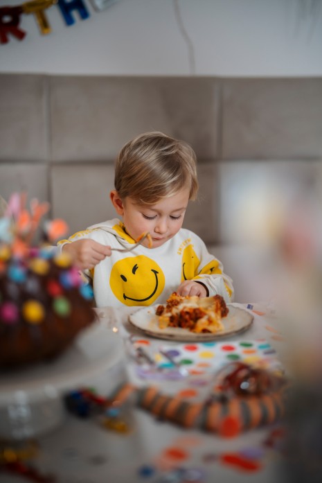 Ein kleiner Bub genießt die Nudeltorte