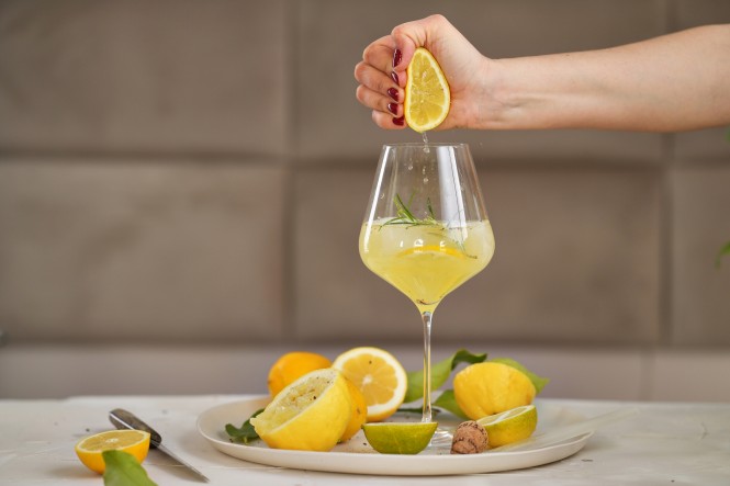 Zitronenhälfte wird über dem Limoncello-Glas ausgepresst