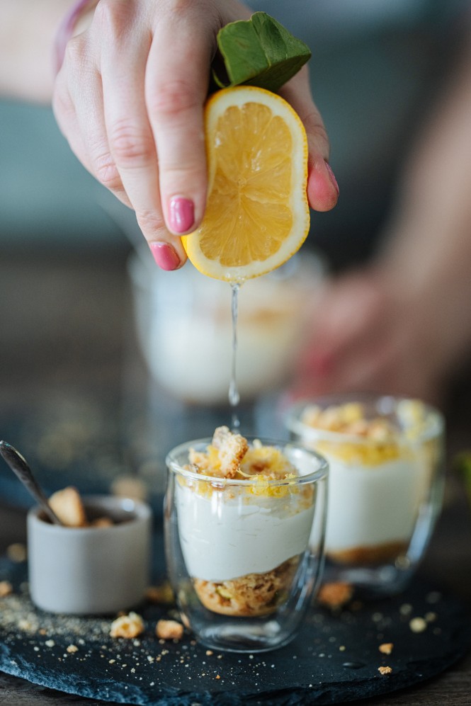 Zitrone wird über dem Limoncello Mousse ausgepresst