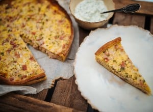 Ein Quiche Lorraine-Stück wird auf einem Teller serviert