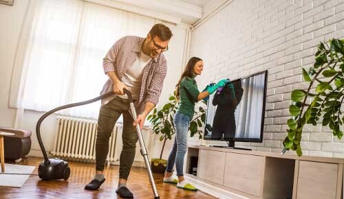 Mann und Frau putzen die Wohnung