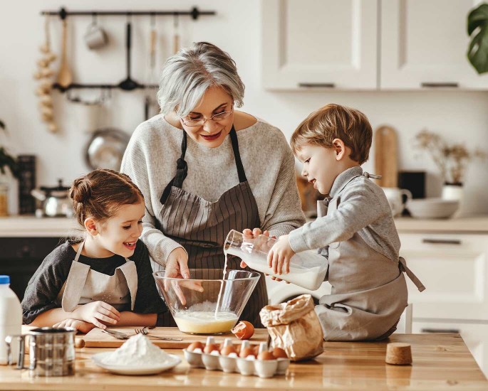 Oma backt mit Kindern einem Mädchen und einem Jungen