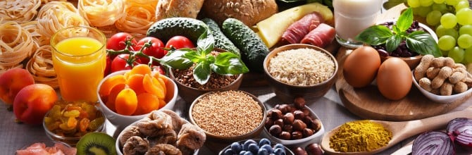 Composition with assorted organic food products on wooden kitchen table.
