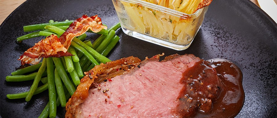SPAR Mahlzeit rosa gebratenes Beiried mit Gewürzsauce, Rosmarin-Kartoffel-Gratin und Speckfisolen