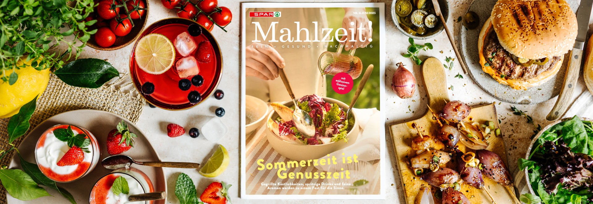 Bild mit einem gedeckten Tisch mit einem Erdbeerdessert, Burger, einem Drink und vielem mehr,