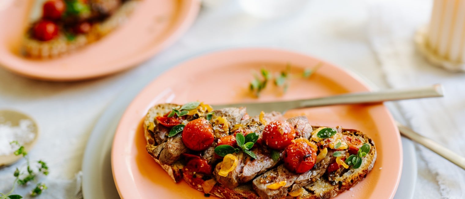 Rinder Steak mit karamellisierten Knoblauch-Tomaten auf gegrilltem Brot 
