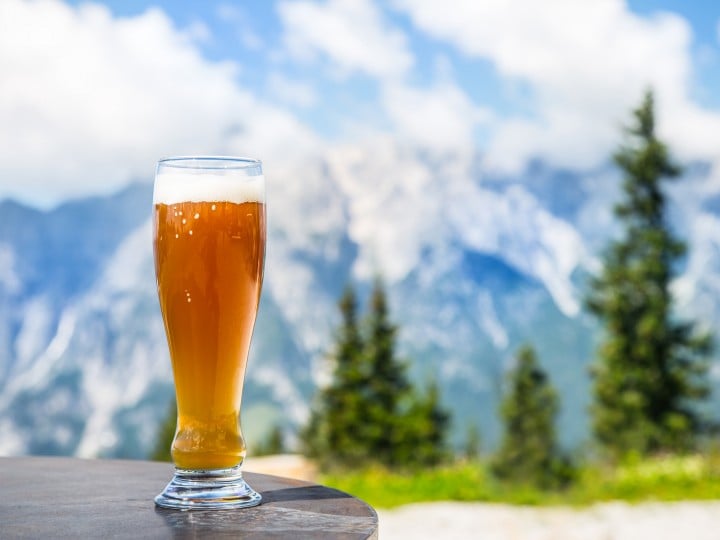 Weißbier steht auf Tisch, Berge im Hingtergrund