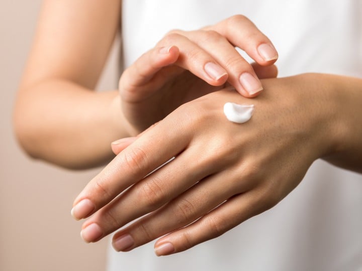 skincare. close up view of woman hand moisturising them with cream. skincare.