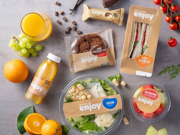 SPAR enjoy Produkte - Smoothie, Ceasar Salat, Melonen Mix, Chocolate Cookie, Käse-Schinken-Sandwich, Topfen-Vanille-Riegel mit frischen Obst auf einer Steinplatte