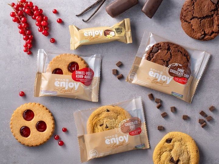 SPAR enjoy Produkte - Chocolate Chips, Linzeraugen und Vanille-Topfen-Riegel mit Ribiseln auf einer Steinplatte